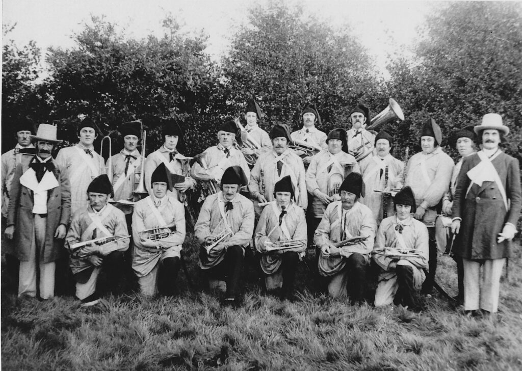 Les membres de l'harmonie en costume de combatants de 1830, leurs instruments en main.